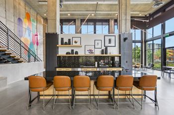 A modern kitchen with a bar area and chairs.